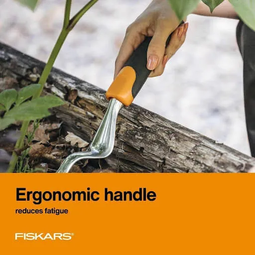 Fiskars hand trowel with an ergonomic handle digging into soil beside a log
